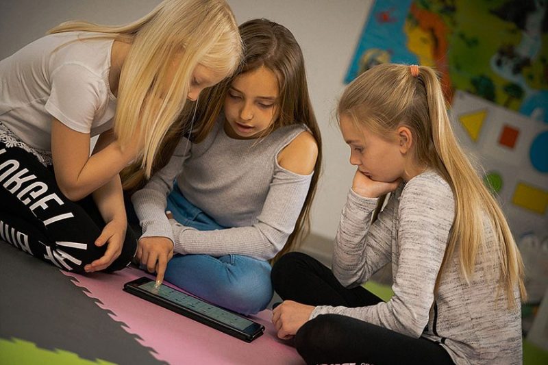 Drei Mädchen im Alter von 9 Jahren programmieren auf dem Tablet.