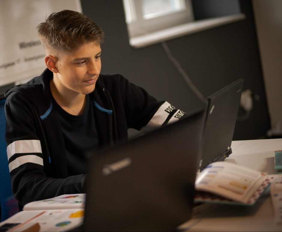 Ein Jugendliche lernt programmieren am Computer